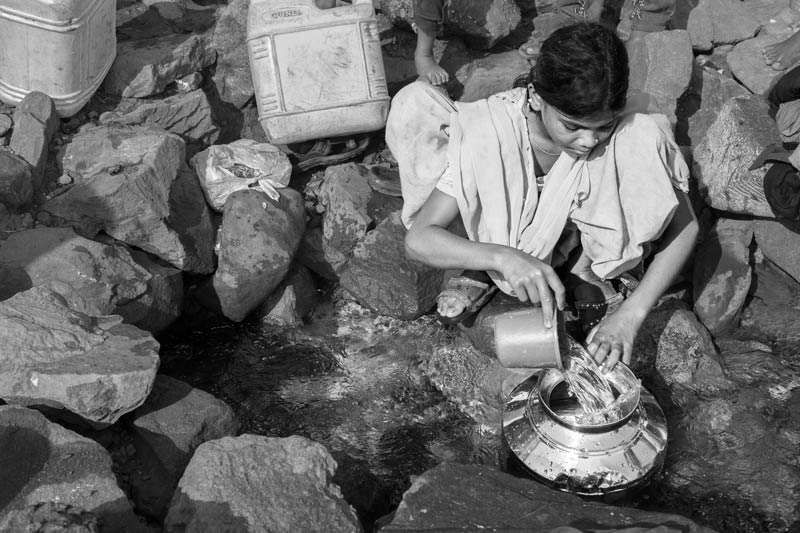 Human Right to Water in Mumbai - Filling water for drinking and cooking from a 'spring' sourced from leakage of a watermains